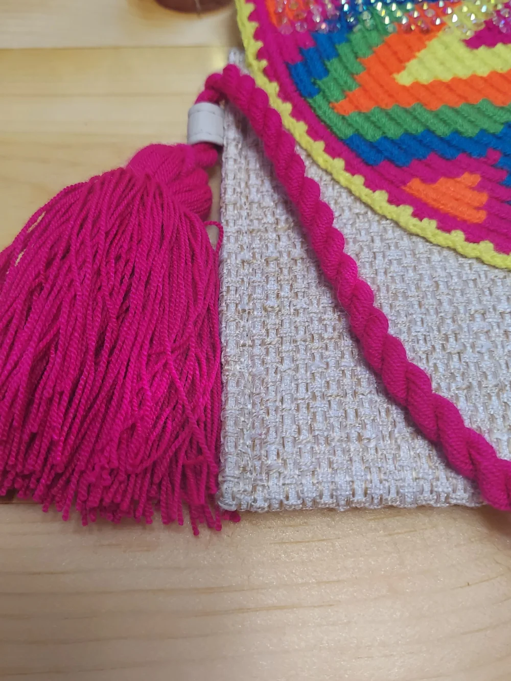 Handmade Wayuu-style jute clutch featuring a vibrant, multicolored beaded floral